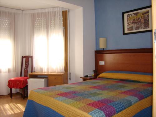 坎布里尔斯海滩旅舍的一间卧室配有一张带彩色毯子的床