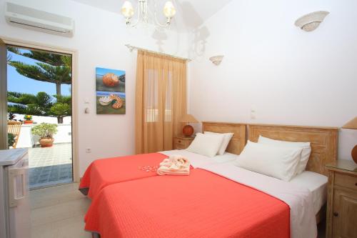 纳乌萨安娜膳食公寓旅馆的一间卧室配有一张带红色毯子的床