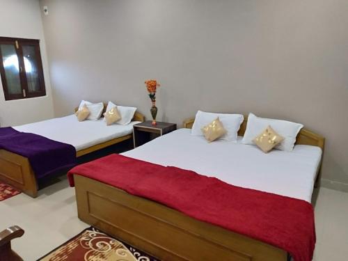 UmariāHotel Jungle Palace Resort的配有红色和白色毯子的客房内的两张床
