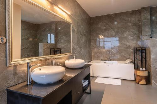 MwendoCLEO LAKE KIVU HOTEL的一间带两个盥洗盆和大镜子的浴室