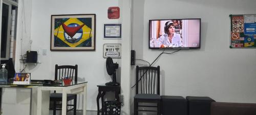 福塔莱萨萨沃伊坡思达宾馆的一间设有椅子和墙上电视的房间