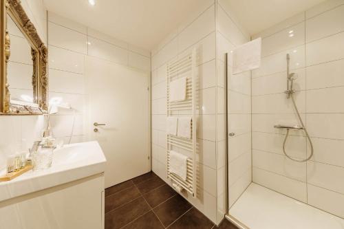 费尔德巴赫费勒博格斯图贝酒店的带淋浴和盥洗盆的白色浴室