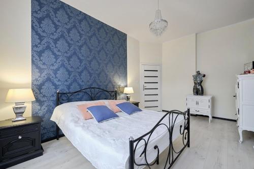 斯扎瓦诺泽德霍Art Apartment Szczawno Zdrój的一间卧室设有一张床和蓝色的墙壁