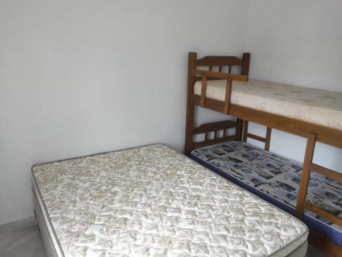 卡拉瓜塔图巴Riviera Massaguaçu 23的两张双层床,彼此相邻,位于一个房间里