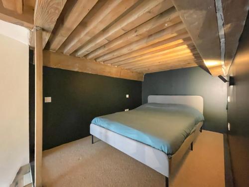 里昂Le soyeux的木天花板的客房内的一张床位