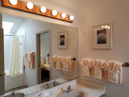 新港Schooner Landing的一间带两个盥洗盆和大镜子的浴室