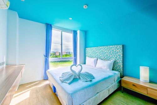 乔木提恩海滩Atlantis Residence的蓝色卧室,配有一张床,床上有一个弓
