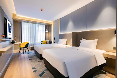 西安西安高新科技路智选假日酒店的酒店客房设有四张床和书桌