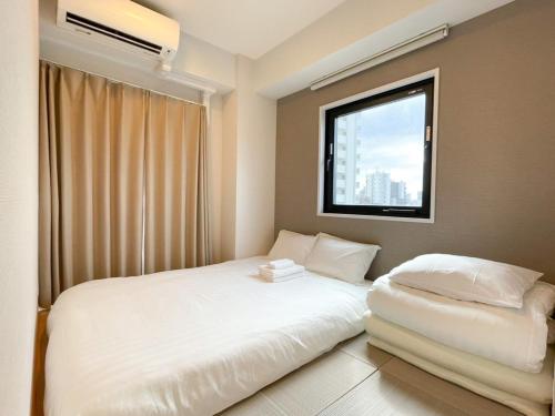 东京The Light Inn Tokyo的一间卧室设有两张床和窗户。