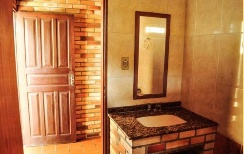 瓜尔达恩巴Moradas Girassol的一间带水槽、镜子和门的浴室