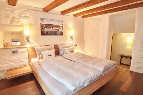 凯尔海姆Turmhotel zum Erasmus的一间卧室配有一张带白色床单的大床