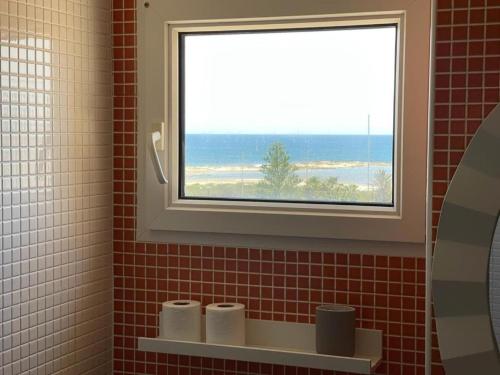 拉曼加戴尔马尔梅纳El Remanso III的浴室设有窗户和带卫生纸的架子。