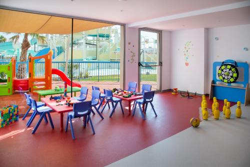 普罗塔拉斯Atlantica Aqua Blue的游戏室设有桌椅和游乐场