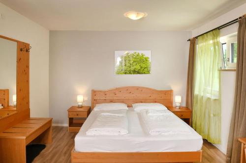 塞纳莱斯Texel Apartments的一间卧室配有一张带白色床单和两盏灯的床。