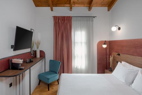约阿尼纳NAIADES the residence ioannina castle的酒店客房,配有一张床和一张蓝色椅子