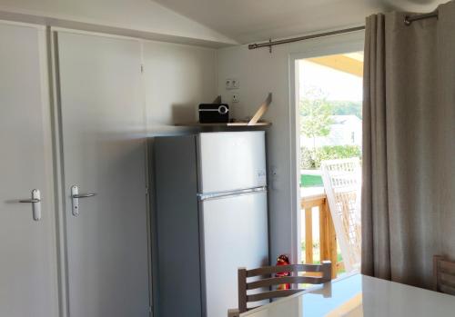 翁赞Assist' Mobil Home 377 - Mobil Home 3 chambres 6 Personnes的厨房配有冰箱和滑动玻璃门