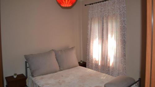 埃拉蒂特里卡隆Elati Mansion的一间卧室配有床和带窗帘的窗户