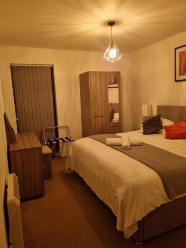 利物浦The Symphony Apartment的酒店客房设有两张床和吊灯。