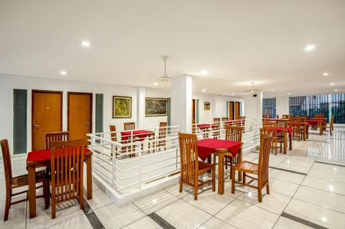 日惹Sans Hotel Prime Cailendra Yogyakarta by RedDoorz的一间设有红色桌椅的用餐室