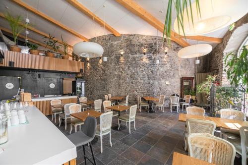 塔林Rija Old Town Hotel的一间带桌椅的餐厅以及砖墙