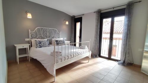 卡塞雷斯Apartamentos Turísticos ENCANTO的一间设有白色床的卧室,位于带窗户的房间内