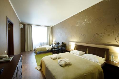 卡卢加卡卢加绿色公园酒店的酒店客房,配有带毛巾的床