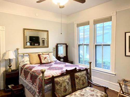 圣安东尼奥Brackenridge House Bed and Breakfast的卧室配有床、镜子和窗户。