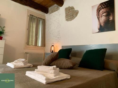 费拉拉Green Rooms Ferrara的一间设有床铺和毛巾的房间