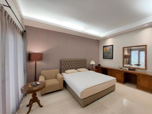 雅加达Via Renata Prapanca的配有一张床和一把椅子的酒店客房
