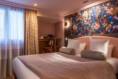 巴黎Maison Axel Opéra的卧室配有一张大床,墙上挂有绘画作品
