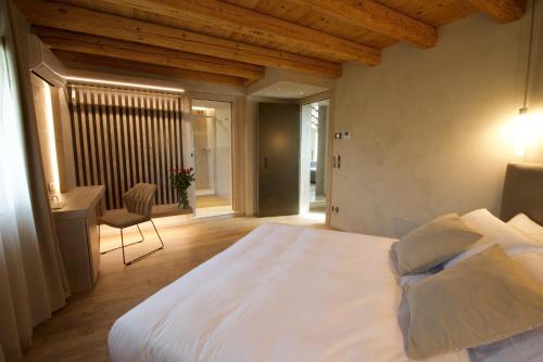 瓦尔多比亚德内Locanda MaMaGiò的卧室配有一张白色大床和一张书桌