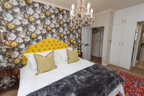 斯泰伦博斯巴鲁克宾馆的一间卧室配有一张带黄色床头板的大床