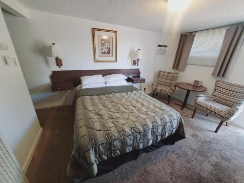 谢里登Holiday Lodge的卧室配有1张床、1张桌子和1把椅子