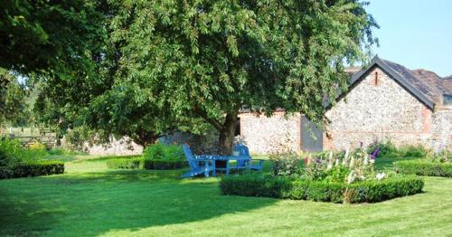 塞特福德田庄农场住宿加早餐旅馆的一个带蓝色长椅和一棵树的院子