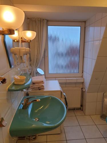 鲁尔河畔米尔海姆Calabria Nr 3的一间带绿色水槽和窗户的浴室