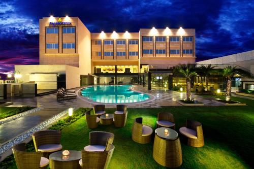Dhāruhera比瓦迪金色郁金香酒店的一座带游泳池和椅子的酒店和一座建筑
