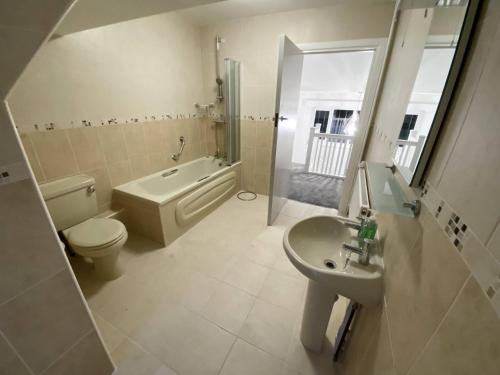 科夫堡Broad Mead的浴室配有卫生间、盥洗盆和浴缸。
