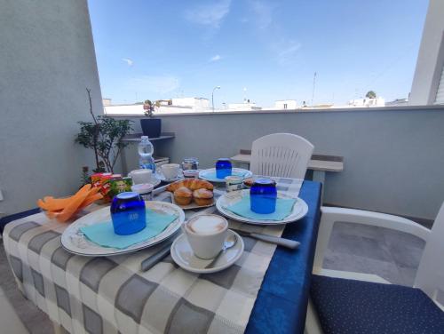 切萨雷奥港B&B DreAm Porto Cesareo的阳台上摆放着食物盘的桌子