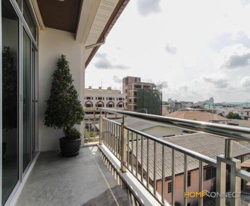 曼谷T系列广场服务式公寓的阳台拥有盆栽树,享有城市美景