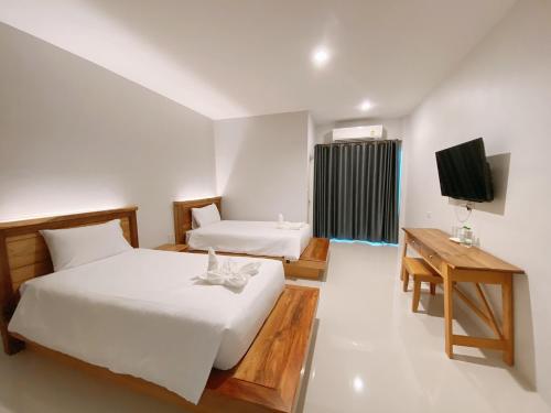 拉廊Greenish Ranong Hotel的酒店客房设有两张床和电视。