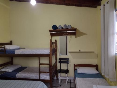 卡拉瓜塔图巴Hospedaria Casa do Sol - divisa Caraguá e São Sebá的带三张双层床和镜子的客房