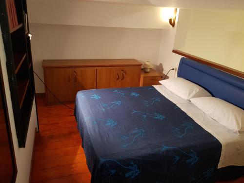 圣欧费米亚拉默齐亚Modern Apt REVENTINO - Le Lincelle, Lamezia的一间卧室配有一张带蓝色棉被的床