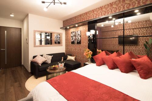 大阪@RLiS_house大阪ドームシティ的酒店客房配有一张带红色枕头的大床