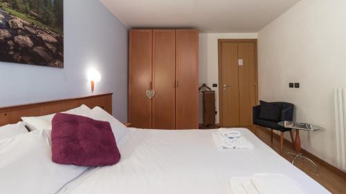 奇萨瓦玛兰科Residence Pizzo Scalino的一间卧室配有一张带紫色枕头的床