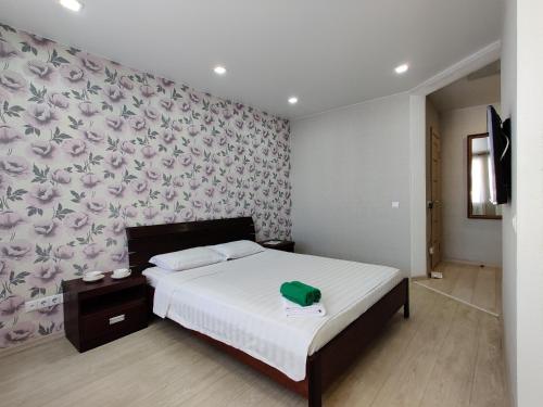 博布鲁伊斯克Apartament on Oktyabrskaya 132的一间卧室配有一张带花卉图案墙壁的床
