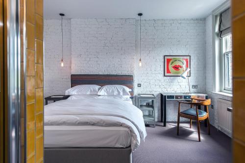 伦敦托米菲尔德酒店的一间卧室配有一张床、一张桌子和一把椅子