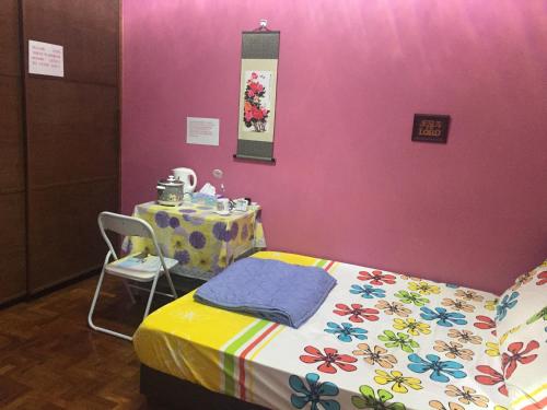 新加坡COMFORTABLE MASTERBEDROOM SUITE的配有床和桌子以及粉红色墙壁的房间