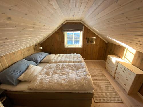 RaulandEndely - ski inn / ut的木制客房内的一间卧室,配有一张床