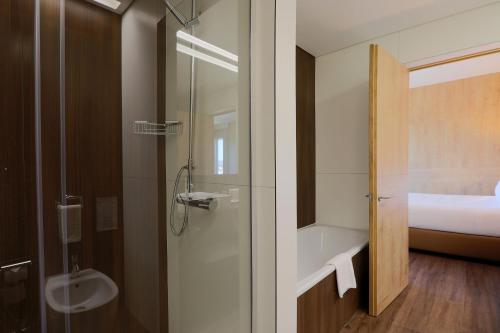 吉马良斯帆迪朵酒店的带淋浴、盥洗盆和卫生间的浴室