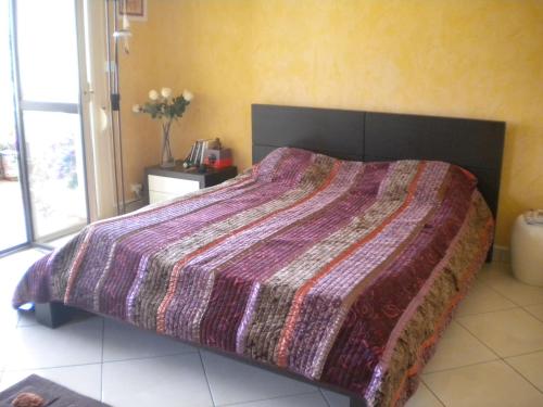 阿雅克修瓦格拉姆住宿加早餐旅馆的一间卧室配有一张大床和紫色棉被
